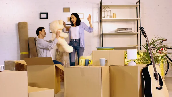 Man Houden Teddy Beer Buurt Verbaasd Vriendin Gebaren Woonkamer — Stockfoto