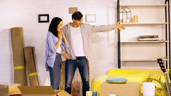 Homem Apontando Com Mão Para Novo Apartamento Perto Namorada Animado — Fotografia de Stock
