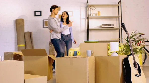 Verschwommener Mann Umarmt Verblüffte Freundin Und Zeigt Neues Zuhause — Stockfoto