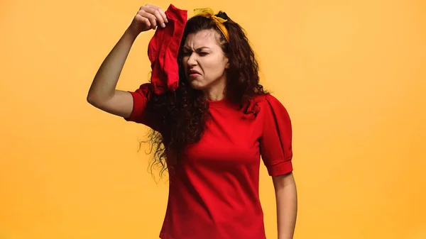 Ung Kvinna Känner Avsmak Medan Håller Stinkande Strumpor Isolerade Orange — Stockfoto