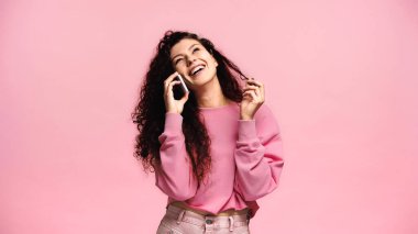 Akıllı telefondan konuşan mutlu bir kadın ve pembe renkte yalnız başına gülen bir kadın.