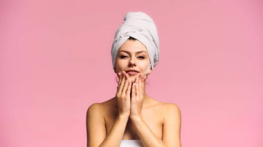 Pembe üzerine izole edilmiş temizlik maskesi takarken gülümseyen genç bir kadın.