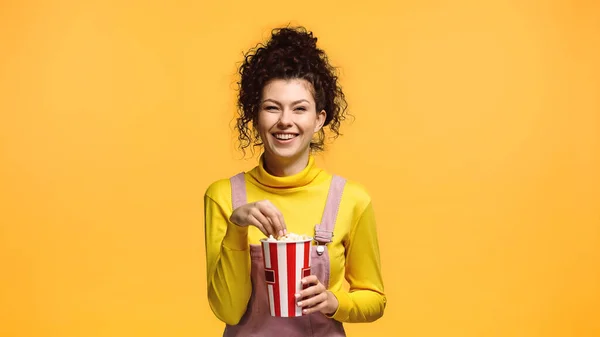 Donna Eccitata Con Secchio Popcorn Sorridente Alla Fotocamera Isolato Arancione — Foto Stock