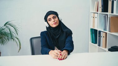 Arap iş kadını tesettürlü kulaklıkla müzik dinliyor