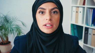 Başörtülü müslüman iş kadını kameraya bakarken konuşuyor