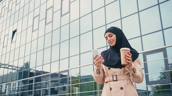 Alegre Joven Musulmana Mujer Hijab Usando Smartphone Sosteniendo Café Para — Foto de Stock