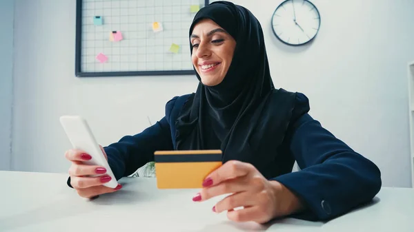 Empresaria Musulmana Sonriendo Mientras Usa Teléfono Inteligente Tarjeta Crédito — Foto de Stock