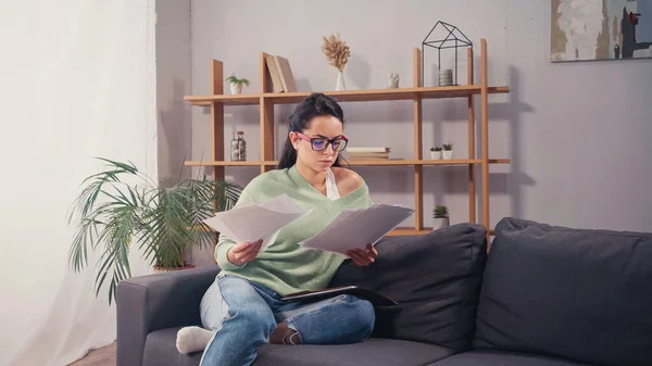 Konzentrierte Studentin Betrachtet Papiere Auf Couch Wohnzimmer — Stockfoto