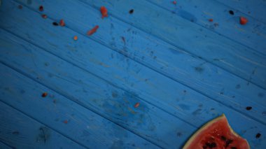 top view of crushed watermelon near seeds on blue surface clipart