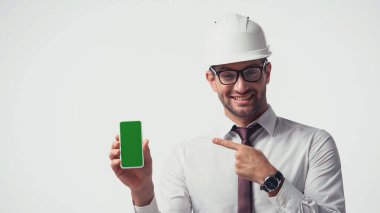 Miğferli mimar, beyaz ekranda yeşil ekranlı cep telefonuna bakıyor.