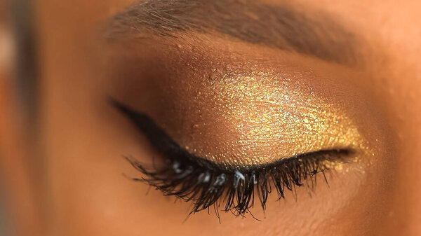 partial view of african american woman with eye makeup 