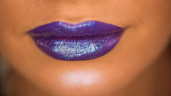 cropped view of woman with shimmer on purple lips 