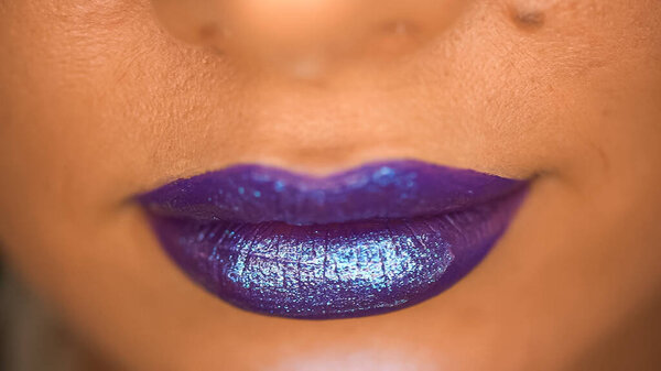 close up of woman with shimmer on purple lips 