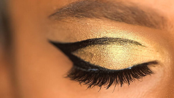 cropped view of african american woman with golden eye shadow and black eye liner