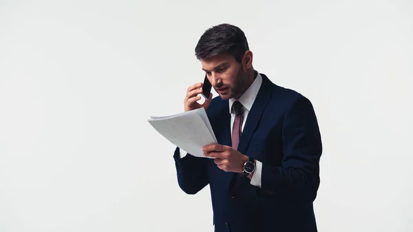 Empresário Olhando Para Documentos Enquanto Fala Smartphone Isolado Branco — Fotografia de Stock