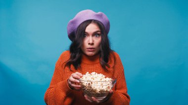 Heyecanlı bir kadın elinde patlamış mısırla tek başına film izlerken
