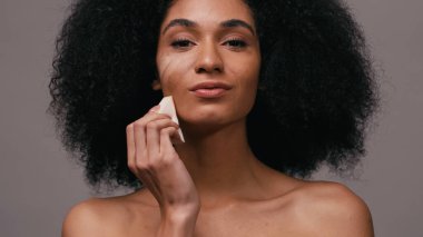 Afro-Amerikan kadın makyaj vakfına Gri Sünger ile başvuruyor.