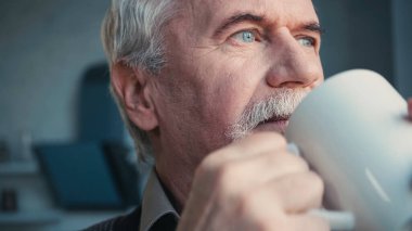 Emekli sakallı bir adamın kahve içerken yüzünü çevirmesine izin verme.  