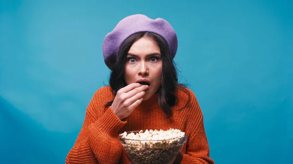 Mujer Preocupada Boina Púrpura Viendo Película Comiendo Palomitas Aisladas Azul — Foto de Stock