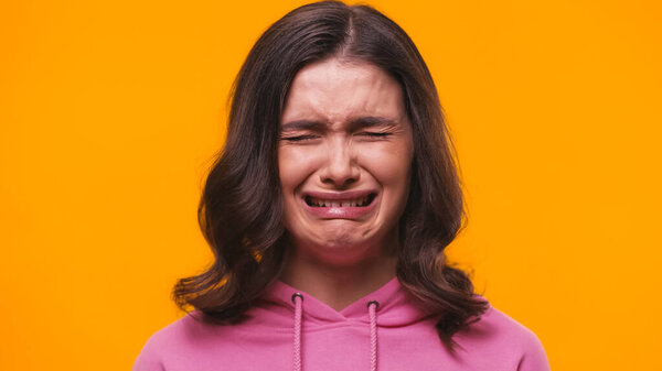 frustrated woman crying isolated on yellow