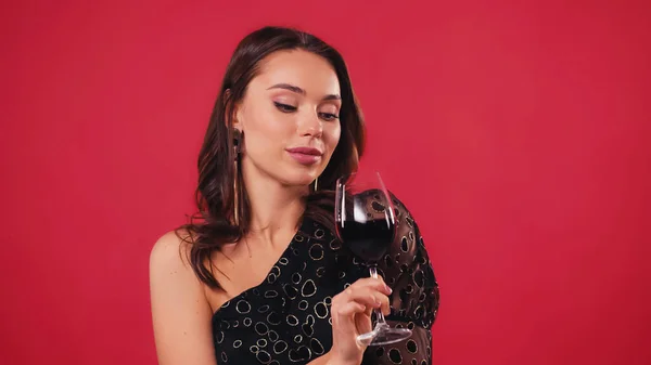 Νεαρή Γυναίκα Που Κοιτάζει Ποτήρι Του Κρασιού Που Απομονώνονται Κόκκινο — Φωτογραφία Αρχείου