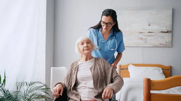 Brunette Nurse Eyeglasses Moving Aged Woman Wheelchair — Stock Photo, Image