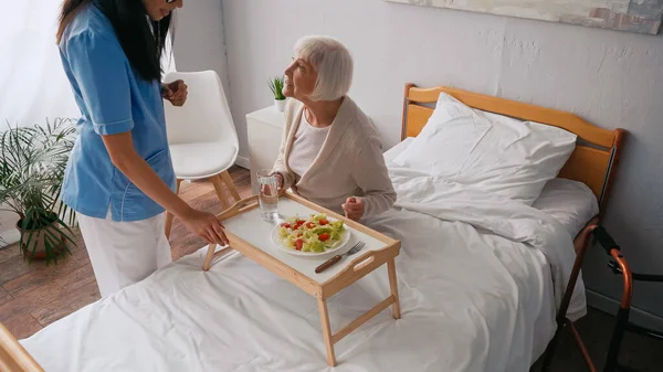 Brunette Nurse Talking Aged Patient Breakfast Tray Bed — Stock Photo, Image