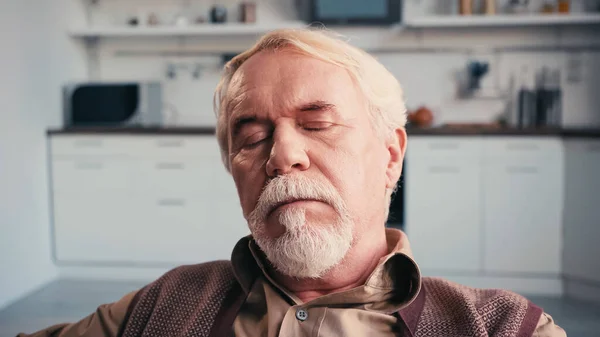 bearded senior man with closed eyes sleeping at home