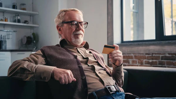 Щасливий Пенсіонер Окулярах Тримає Кредитну Картку Вдома — стокове фото