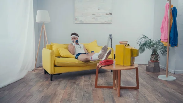 Sportler Mit Brille Trainiert Auf Der Couch Mit Kurzhanteln — Stockfoto