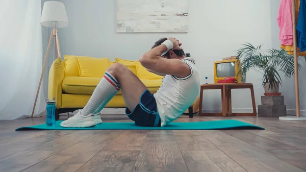 在客厅健身垫上做腹肌运动的运动员的体表水平 — 图库照片