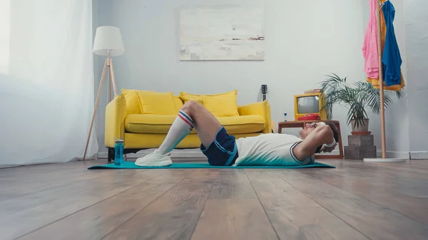 在客厅健身垫上做腹肌运动的运动员的体表水平 — 图库照片