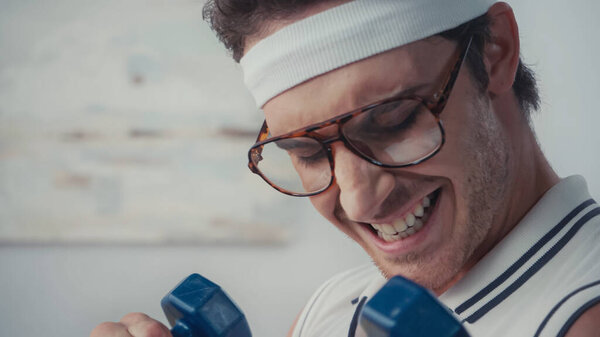 close up of strong sportsman lifting dumbbells, retro sport concept