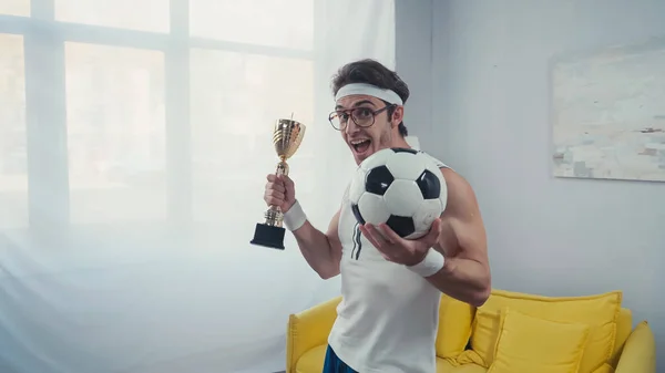 Aufgeregter Fußballer Mit Pokal Und Fußball Feiert Sieg Hause — Stockfoto