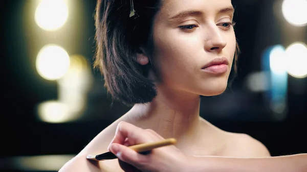 Makeup artist applying foundation on model with cosmetic brush — Stock Photo