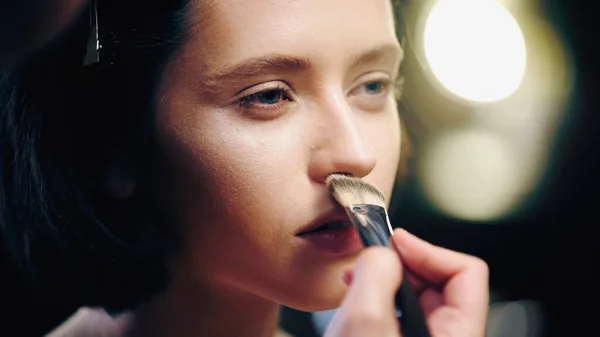 Maquilleur appliquant fond de teint de maquillage sur la peau du modèle — Photo de stock