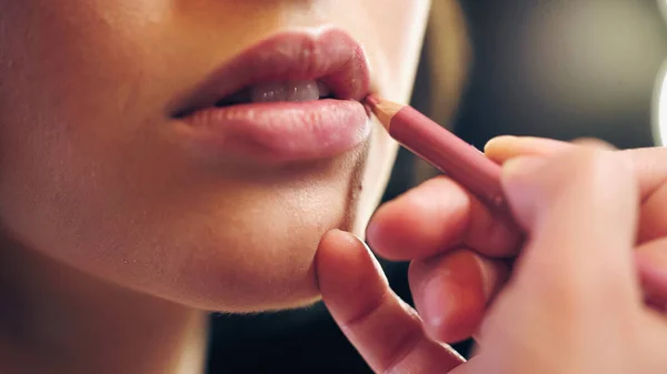 Vue partielle du maquilleur appliquant le revêtement des lèvres sur les lèvres du modèle — Photo de stock