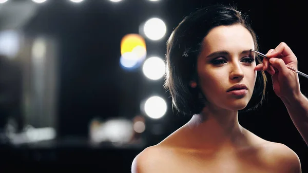 Make-up-Artist trägt Augenbrauentöne mit Kosmetikpinsel auf Modell auf — Stockfoto