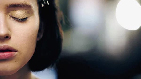 Ausgeschnittene Ansicht einer Frau mit geschlossenen Augen und Concealer auf dem Augenlid — Stockfoto