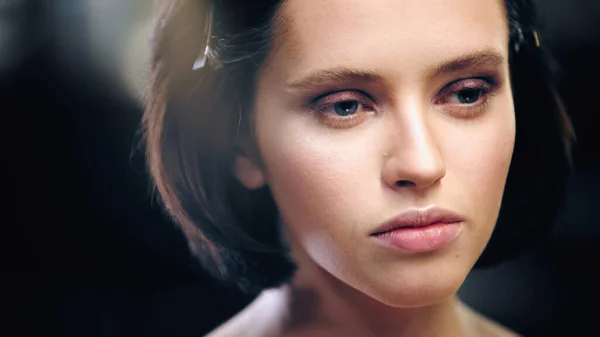 Young brunette model with eye makeup looking away — Stock Photo