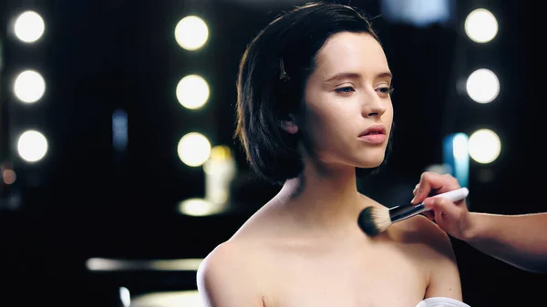 Make-up-Artist trägt Puder auf Schlüsselbeine hübscher Models mit nackten Schultern auf — Stockfoto