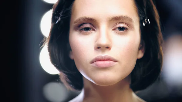 Brunette young model looking at camera with backlit on background — Stock Photo