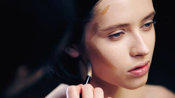 Trucco sfocato artista facendo contouring viso del modello con pennello cosmetico — Foto stock
