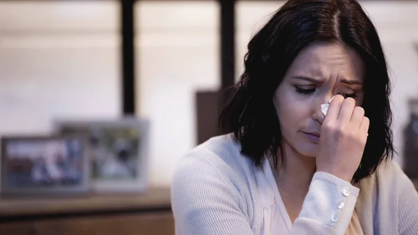 Depressed woman wiping tears with paper napkin at home — Stock Photo