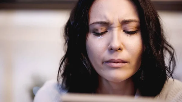 Nahaufnahme einer depressiven Frau, die zu Hause unter Tränen weint — Stockfoto