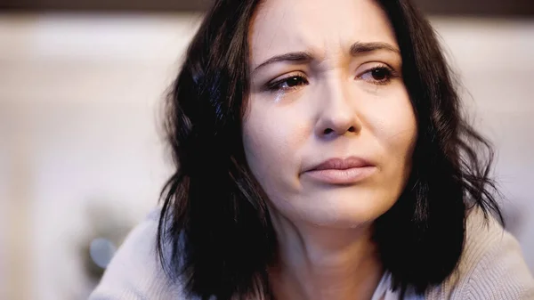 Vista de cerca de la mujer molesta llorando con lágrimas en la cara en casa - foto de stock