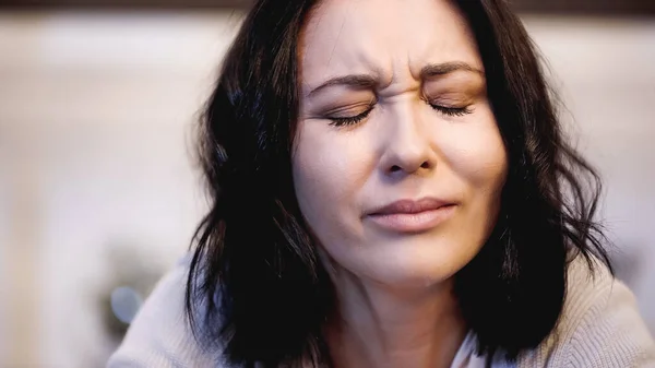 Portrait de femme brune pleurant avec les yeux fermés sur fond beige — Photo de stock