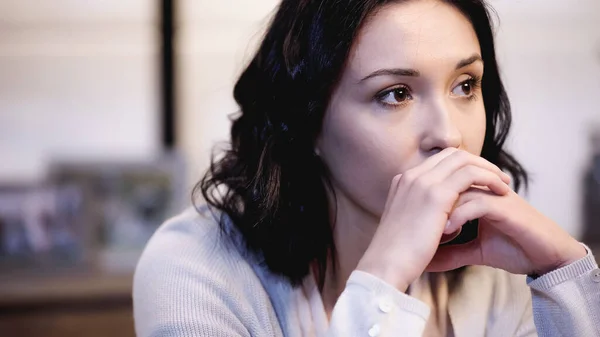 Tired woman covering mouth with clenched hands at home — Stock Photo