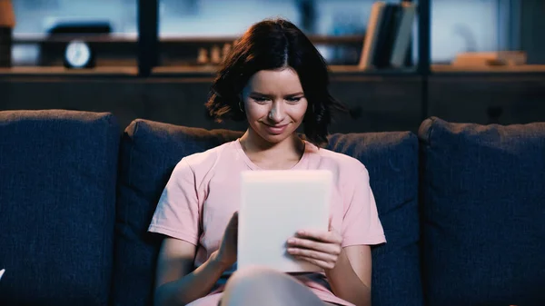 Brunetta giovane donna utilizzando tablet digitale in soggiorno — Foto stock