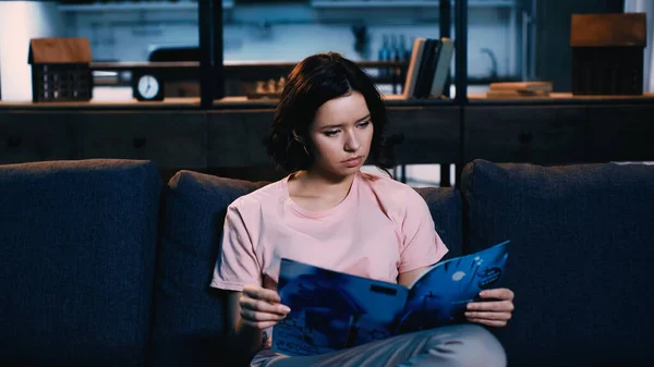 Брюнетка молодая женщина читает журнал дома — стоковое фото